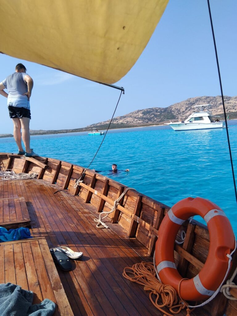 La vela latina vista dal ponte del gozzo, con l'isola dell'Asinara sullo sfondo